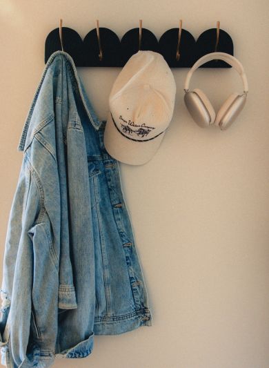 Two people walking up a grassy hill with a cloudy sky and distant landscape in the background near LOCAL Boise apartments.