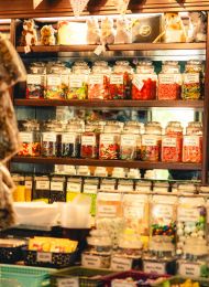 Bearded bartender cleaning a glass at a bar with various bottles displayed on shelves in the background near LOCAL Boise apartments.